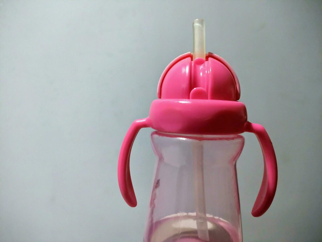 pink children's drink bottle with a straw at the end of the bottle photo