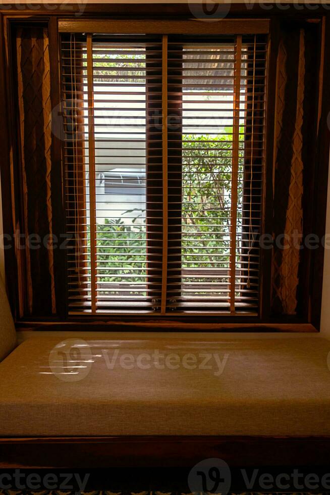 ligero viniendo mediante de madera ventana persianas dentro vivo habitación. foto