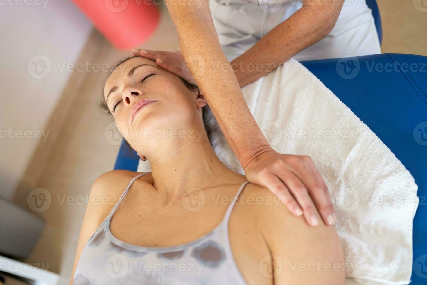 Physiotherapist stretching neck of client in clinic photo