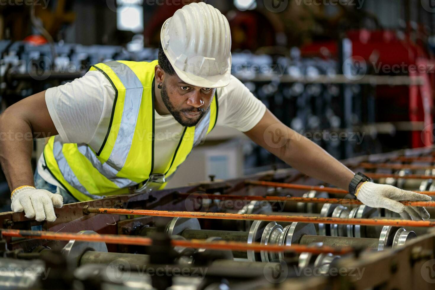 African American industrial worker is checking the setup value of metal sheet roll forming machine inside roof factory for safety industry construction photo