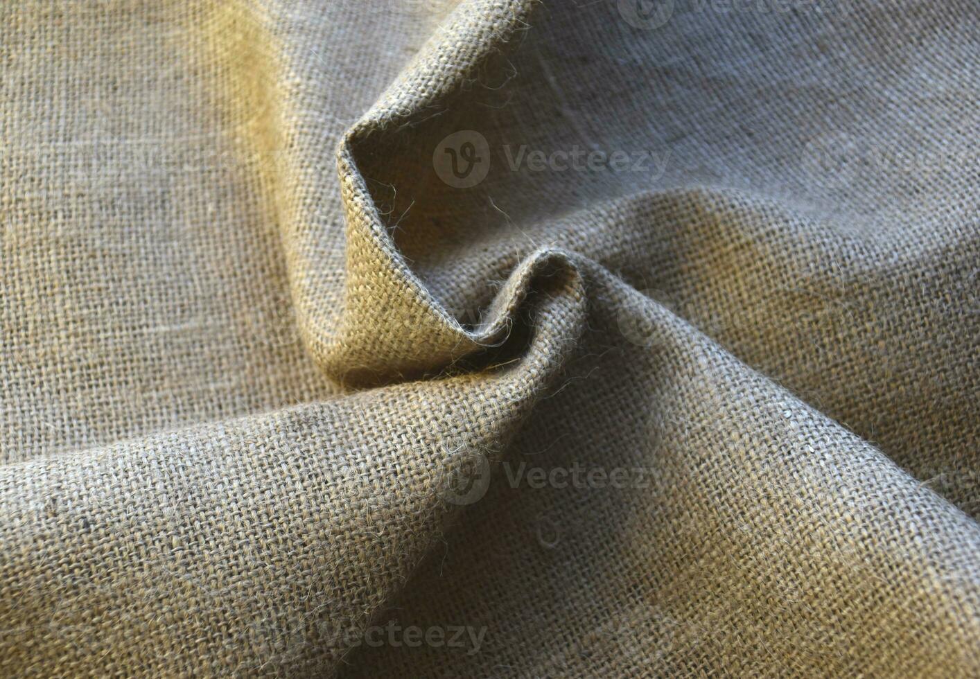 Yellow coiled yellow matter. A piece of burlap. The material for the bags. photo