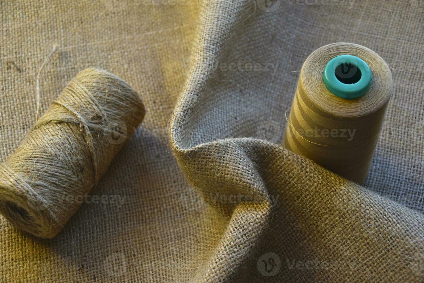 Skeins of thread on crumpled burlap. Yellow threads on coarse cloth. The material for the bags. photo