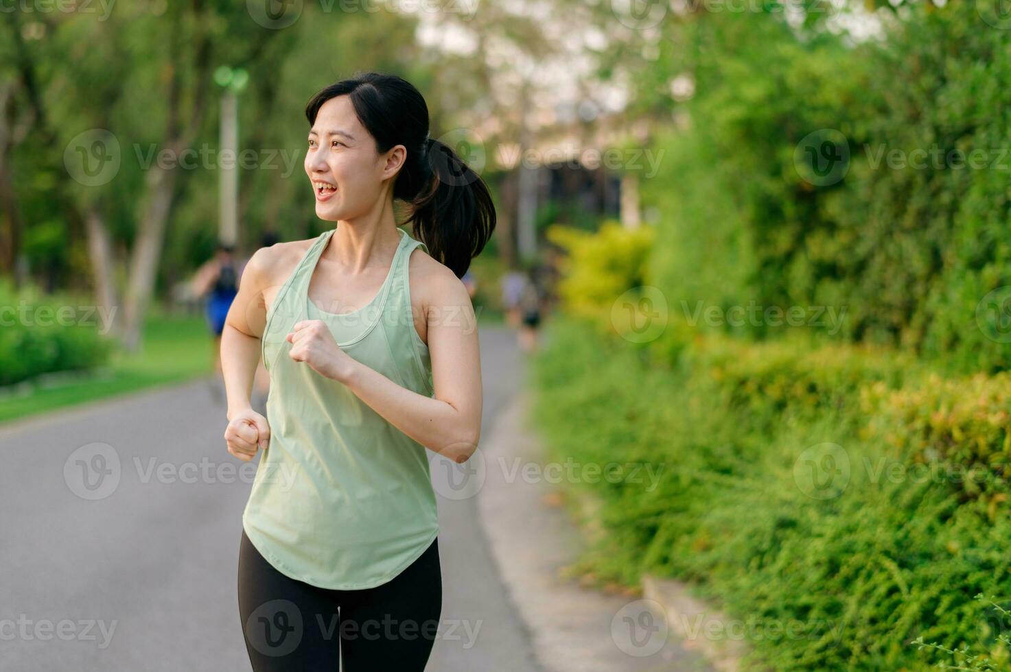 Fit Asian young woman jogging in park smiling happy running and enjoying a healthy outdoor lifestyle. Female jogger. Fitness runner girl in public park. healthy lifestyle and wellness being concept photo