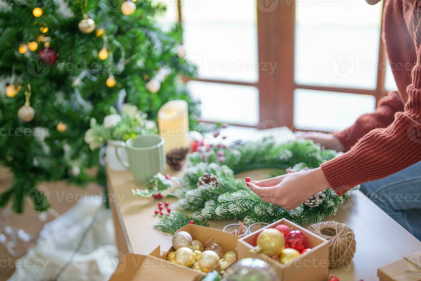 Woman making mistletoe wreath Christmas wreath decoration with hand made DIY winter greenery florist hands making Christmas wreath beautiful mistletoe. photo