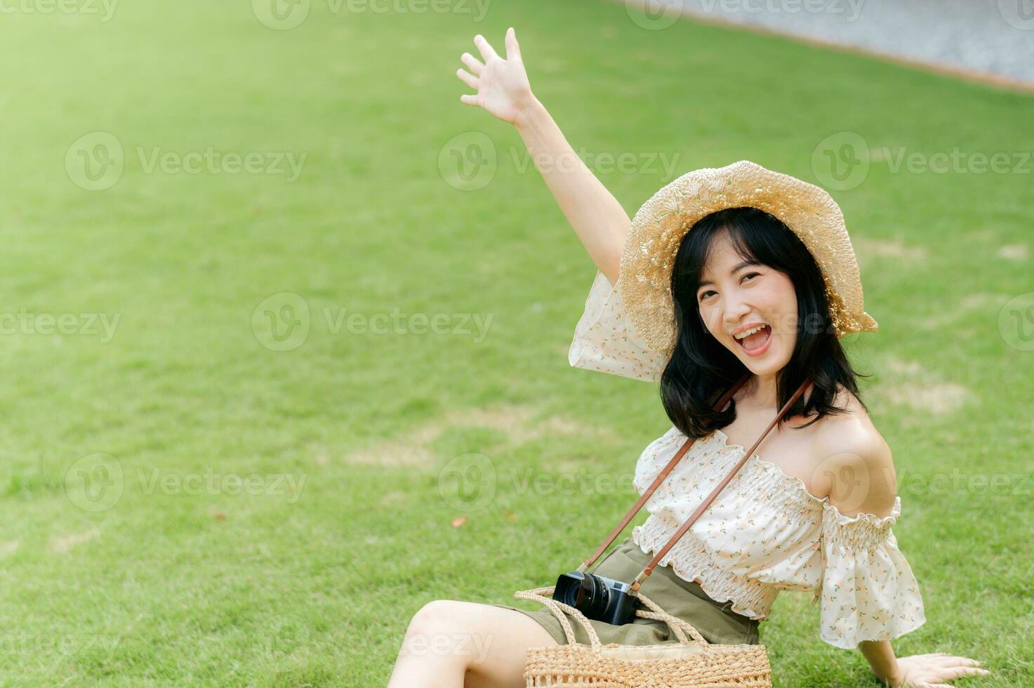 Portrait of asian young woman traveler with weaving hat and basket and a camera on green public park nature background. Journey trip lifestyle, world travel explorer or Asia summer tourism concept. photo