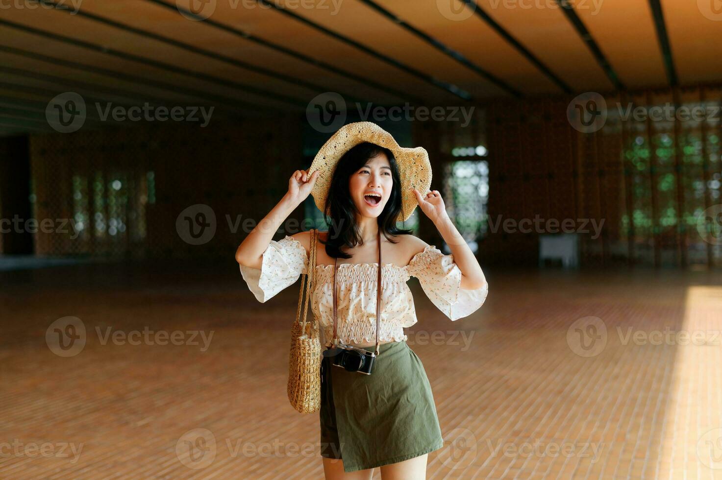 Portrait of asian young woman traveler with weaving hat and basket and a camera on street. Journey trip lifestyle, world travel explorer or Asia summer tourism concept. photo