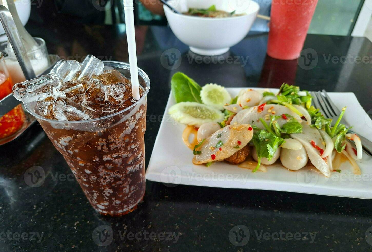 Picture of soft drink with ice and meatball salad photo