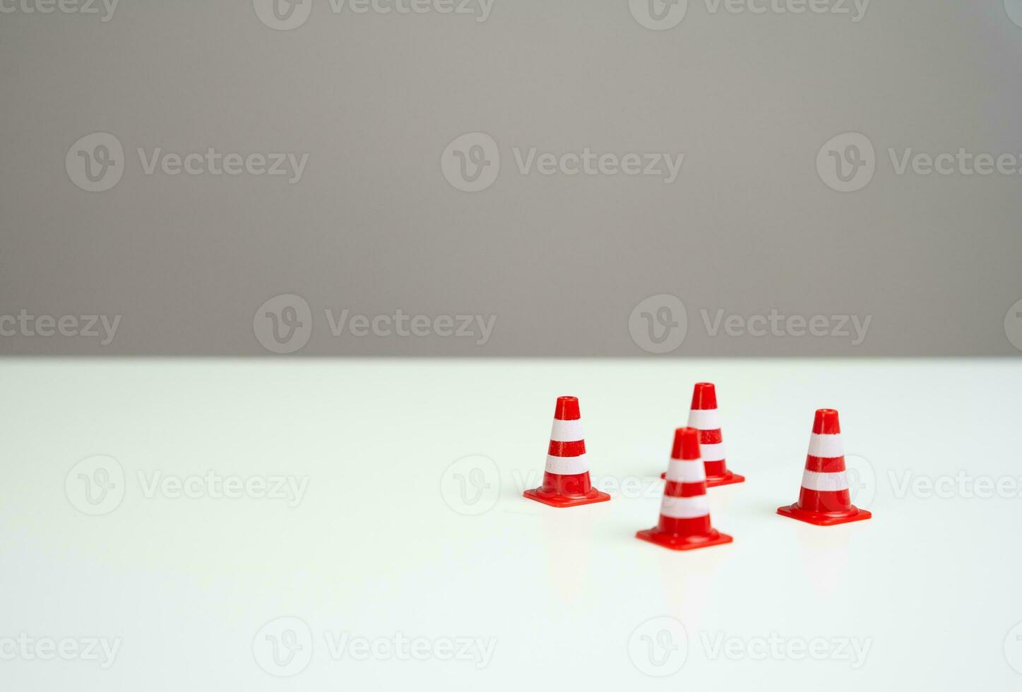 Road cones on a white background. An insurmountable obstacle. Backlog of tasks. On the approach to a difficult challenge. Putting a halt to certain decisions. Deal with problems photo