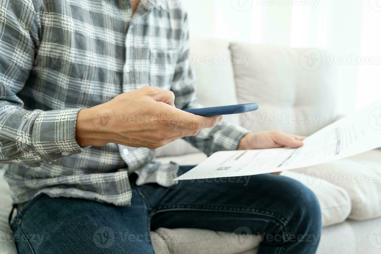 business man use phone to scan barcode or QR codes to pay credit card bill after receiving document invoice online. payment, receive, paying electricity, digital payments without money, technology photo