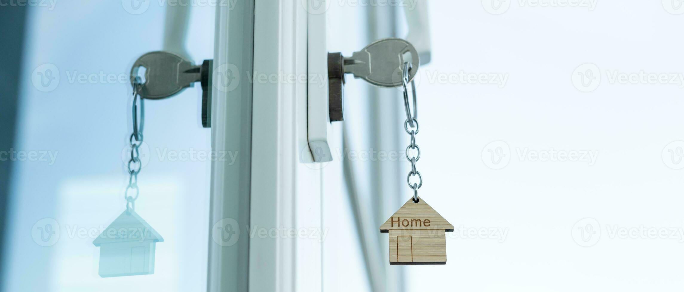 Landlord key for unlocking house is plugged into the door. Second hand house for rent and sale. keychain is blowing in the wind. mortgage for new home, buy, sell, renovate, investment, owner, estate photo