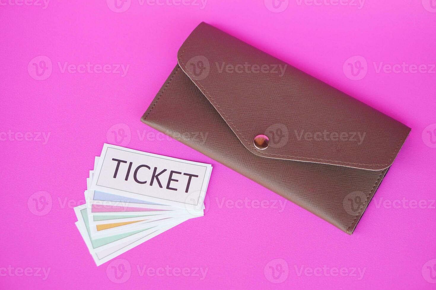 Leather envelope and pile of paper tickets. Pink background. Concept, tickets for passing or enter to join activity or public vehicles. Tickets for playing games. Teaching aids. photo