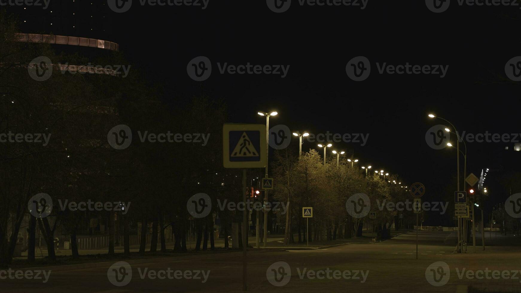 Empty city street with roadway at night. Night devastated city and deserted streets shrouded in peace and tranquility in rays of lanterns photo