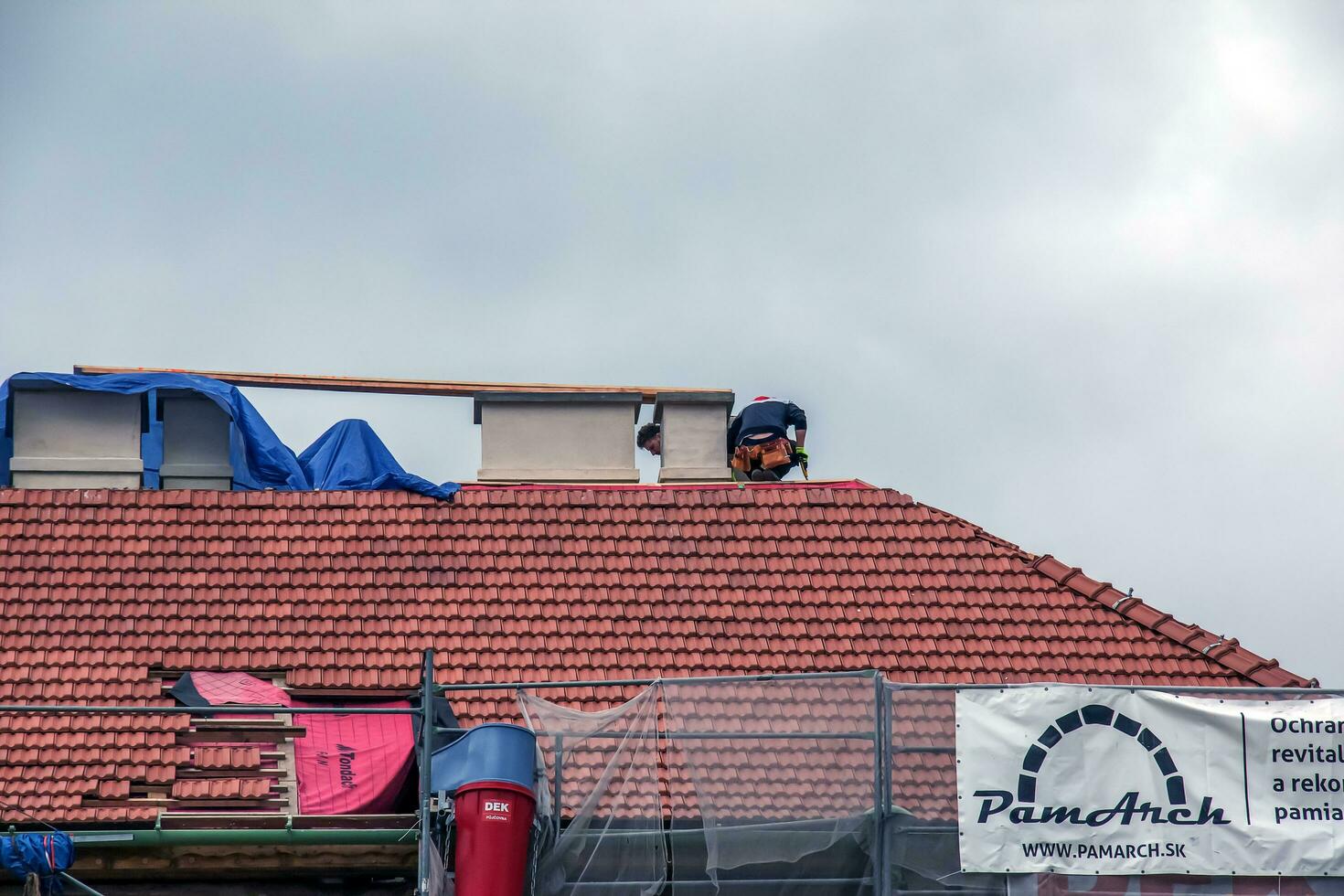 Nitra, Slovakia - 05.15.2023 Handymen repair chimneys on the roof of a house. photo