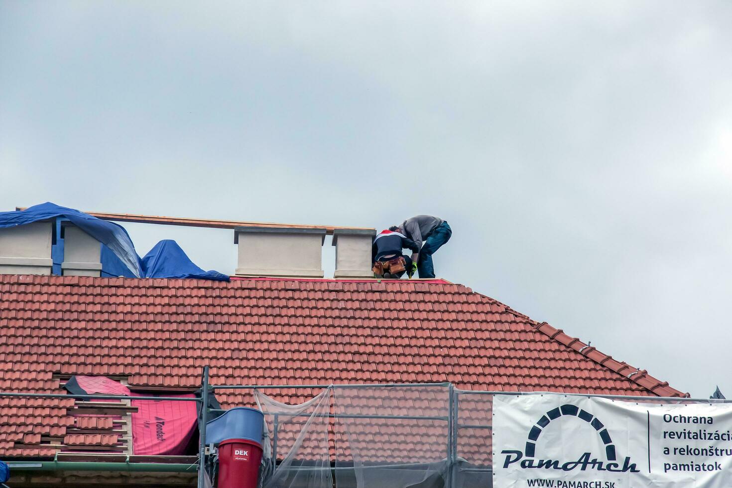 Nitra, Slovakia - 05.15.2023 Handymen repair chimneys on the roof of a house. photo