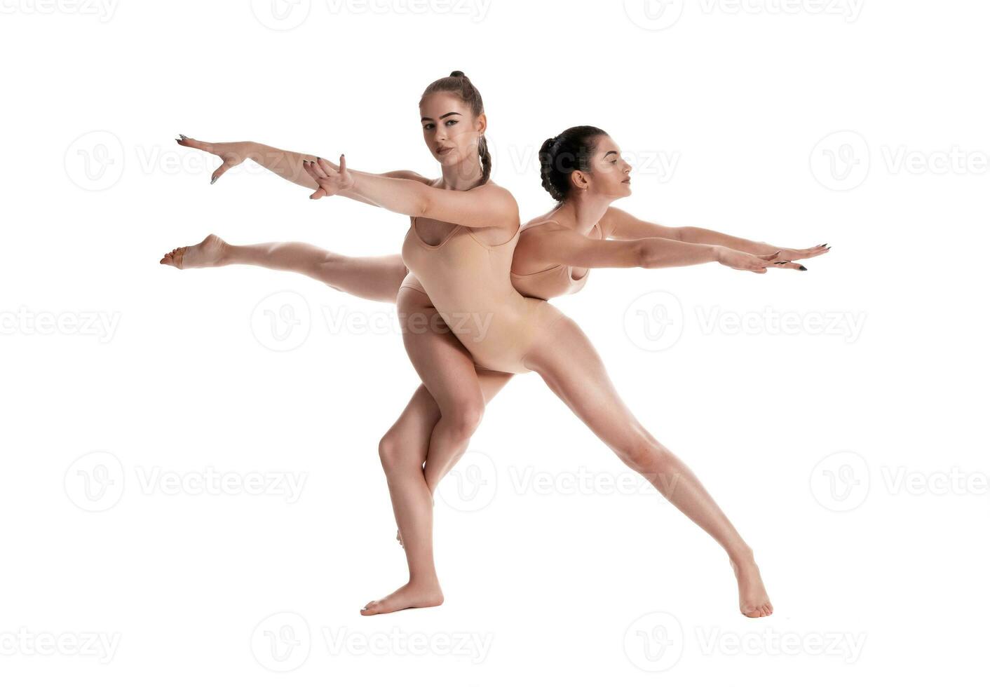 dos flexible muchachas gimnastas en beige leotardos son ejecutando ejercicios utilizando apoyo y posando aislado en blanco antecedentes. de cerca. foto