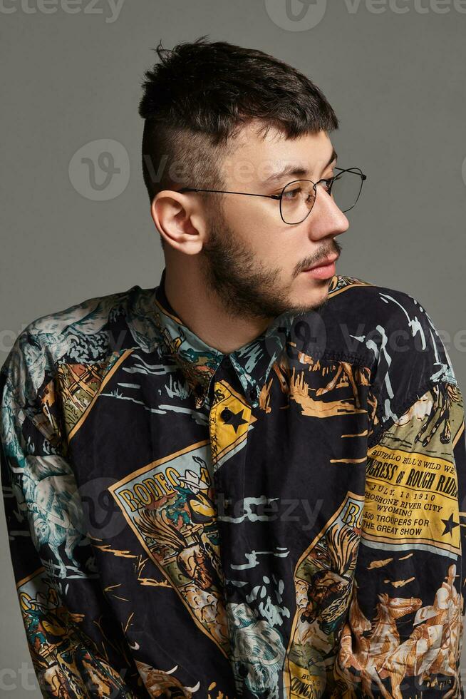 Close-up portrait of a funny guy posing in studio isolated on a gray background. photo