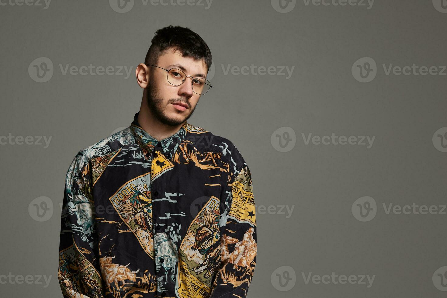 Close-up portrait of a funny guy posing in studio isolated on a gray background. photo