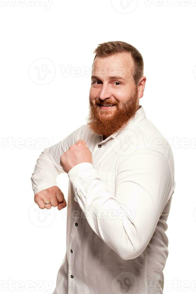 Portrait of a young, chubby, redheaded man in a white shirt making faces at the camera, isolated on a white background photo