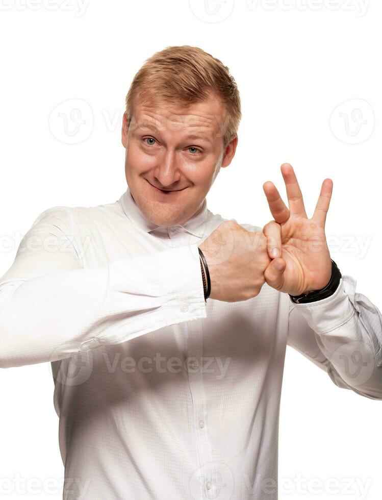 Imposing, young, blond man in a white shirt is grimacing while standing isolated on a white background photo