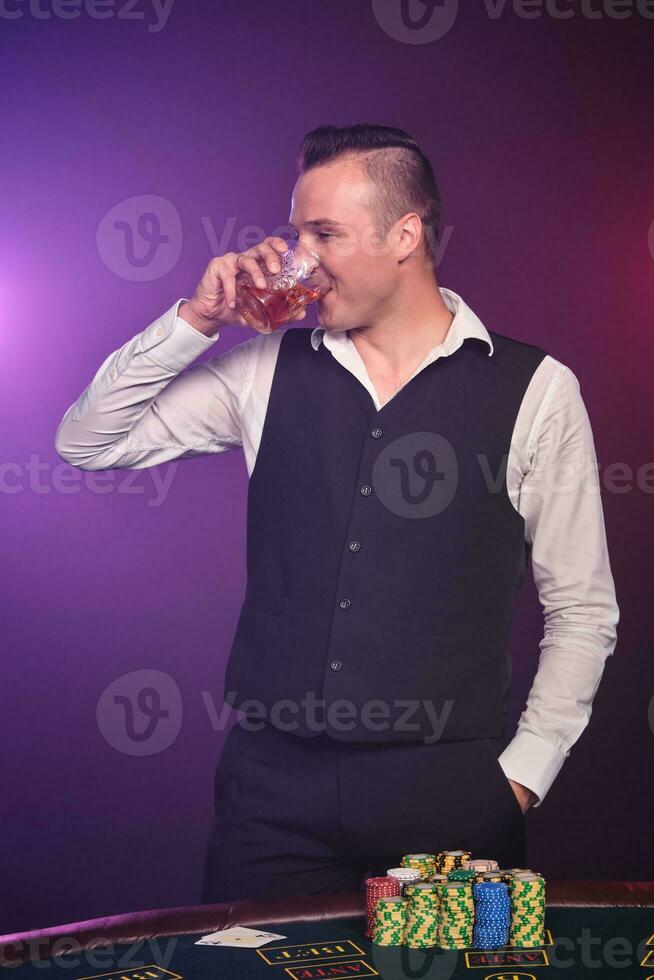 rico hombre es jugando póker con un emoción a un casino en negro antecedentes. foto