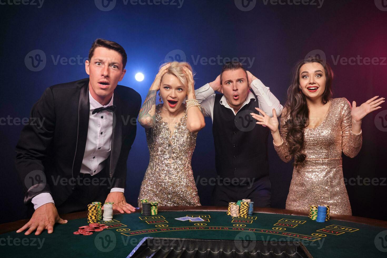 Group of a stylish rich friends are playing poker at casino. photo