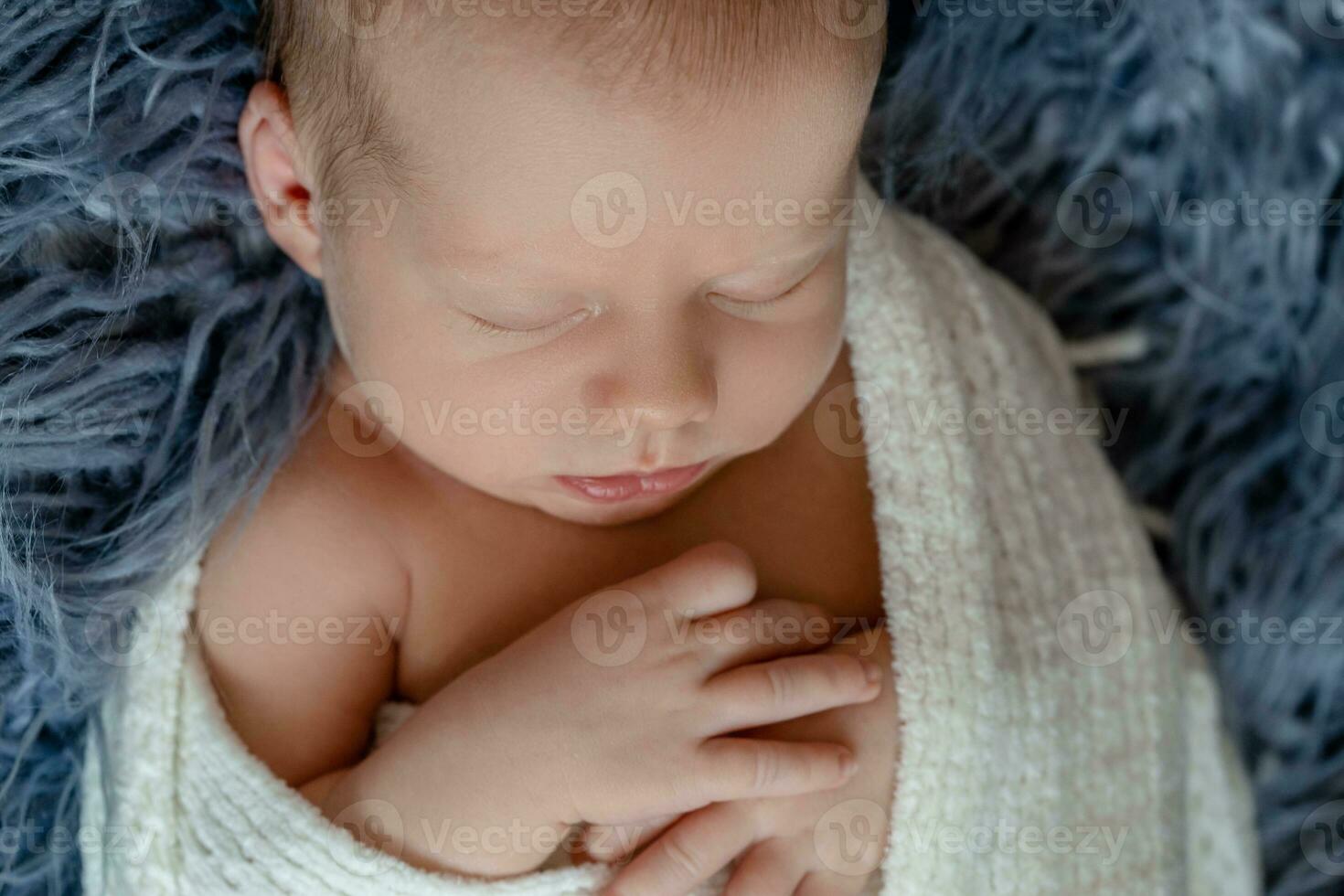 recién nacido bebé chico en cama. nuevo nacido niño dormido debajo un blanco de punto frazada. niños dormir. de cerca foto