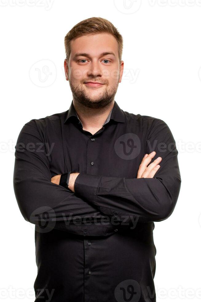 Young man in black shirt is smiling and crossed his arms over chest against white background photo