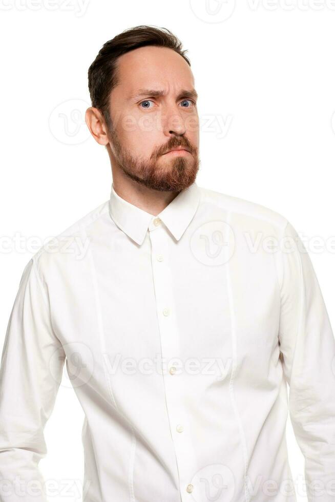 hermoso barbado hombre en un blanco camisa posa, aislado en un blanco antecedentes foto