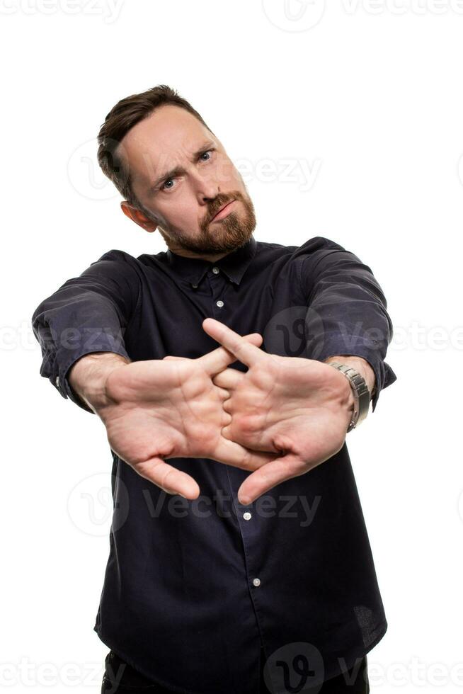 Portrait of a handsome, unshaven man, dressed in a dark blue shirt, standing against a white background. Self confident man. photo