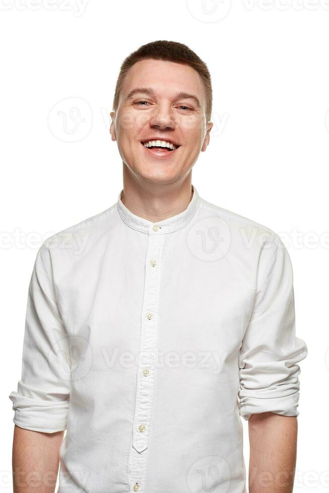 retrato de joven hombre en casual camisa sonriente mientras en pie en contra blanco antecedentes foto