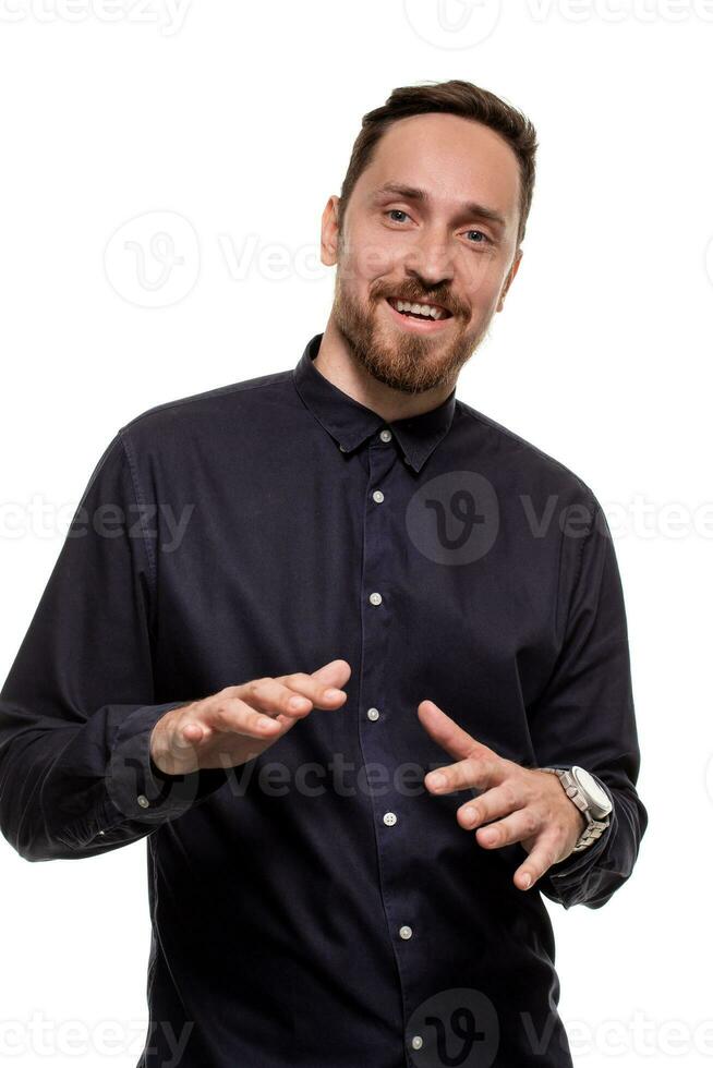 Portrait of a handsome, unshaven man, dressed in a dark blue shirt, standing against a white background. Self confident man. photo