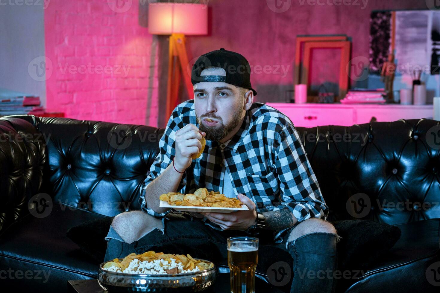 Young supporter man watching football game on television sitting photo