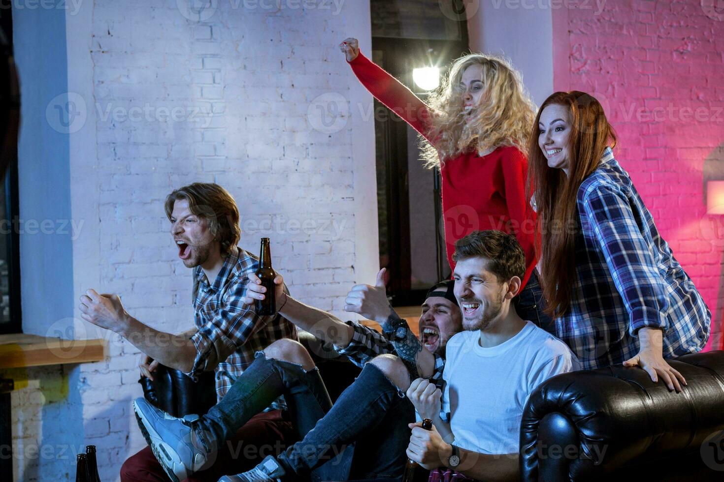 Group of friends having fun at home,watching game and enjoying t photo