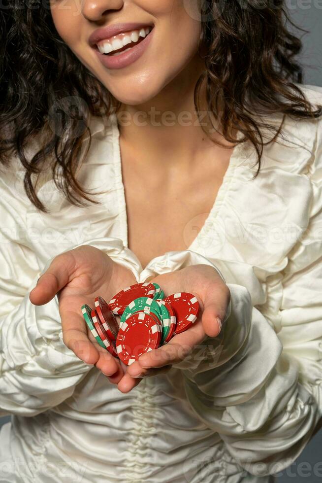 rojo y verde apuesta tokens en palmas de riendo joven mujer foto