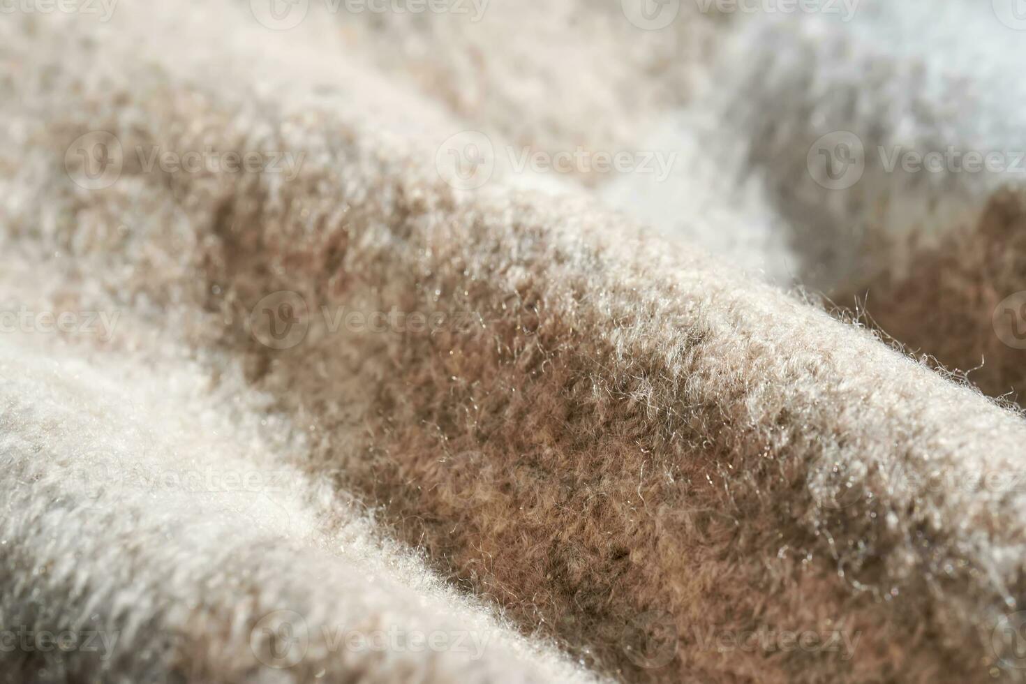 The texture of a warm sweater with a beige pattern. photo