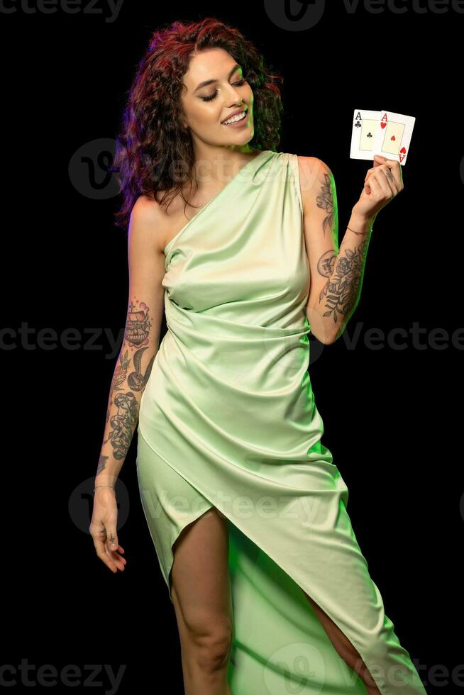 Smiling young woman poker player holding pair of aces photo