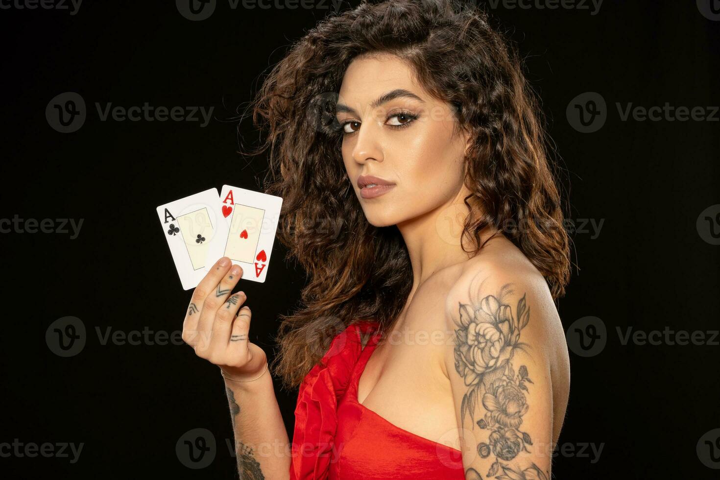 Confident young brunette holding pair of aces with winning look photo