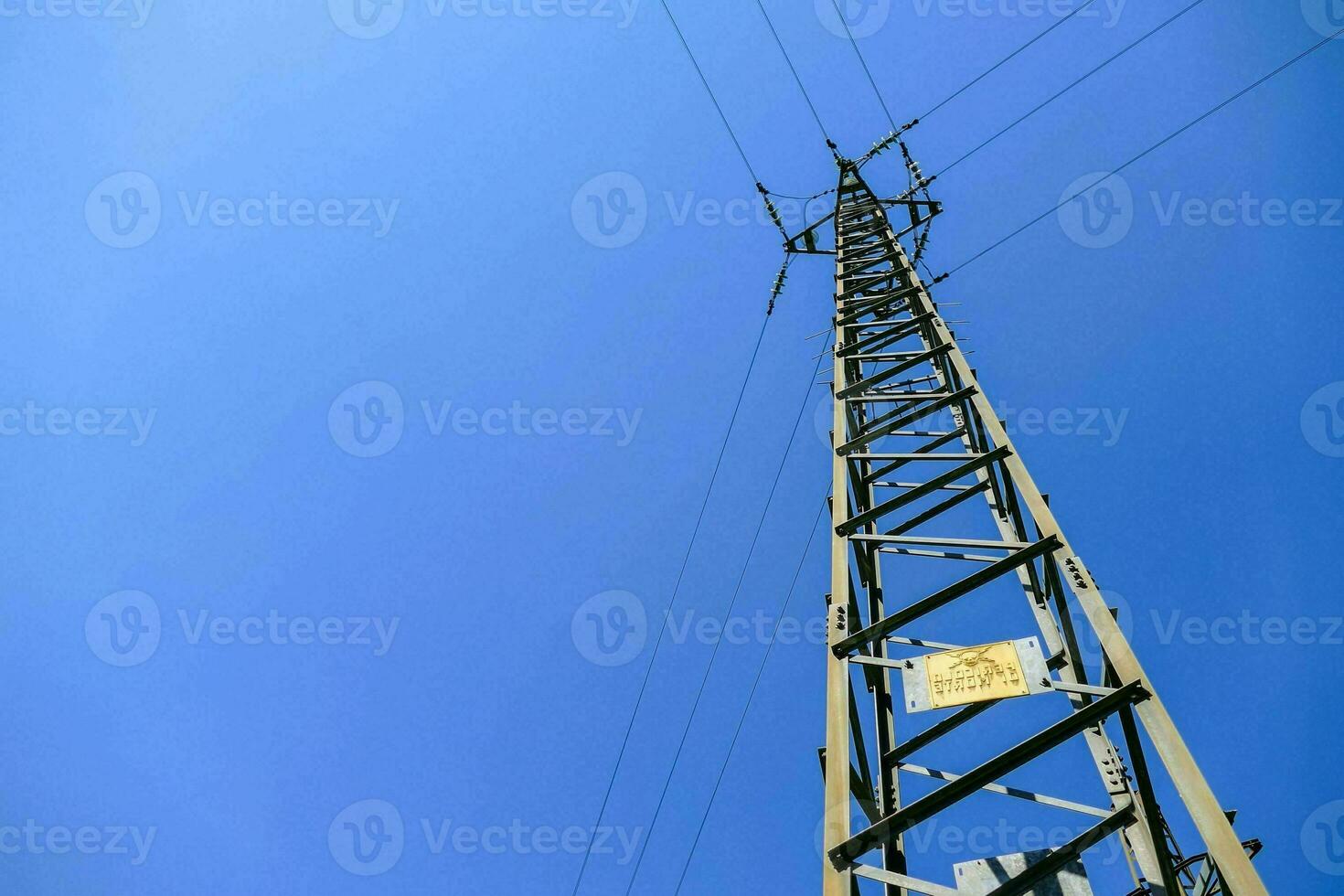 a tall power pole against a blue sky photo