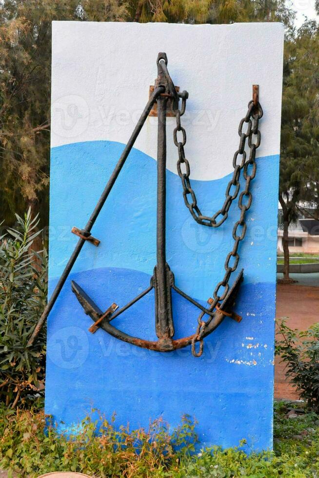 a large anchor on a blue wall photo