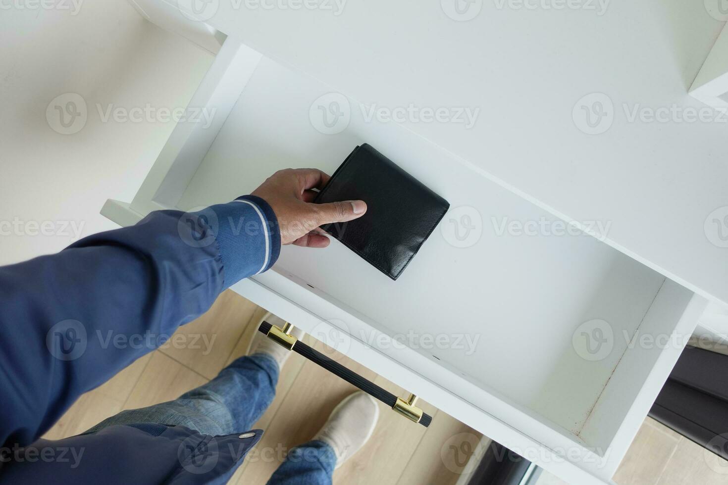 men stealing wallet from a drawer photo