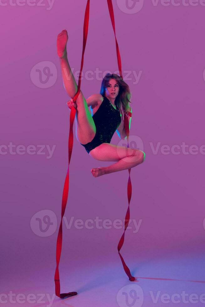 hermosa niña en un negro traje de baño es ejecutando un acrobático elementos en estudio. foto