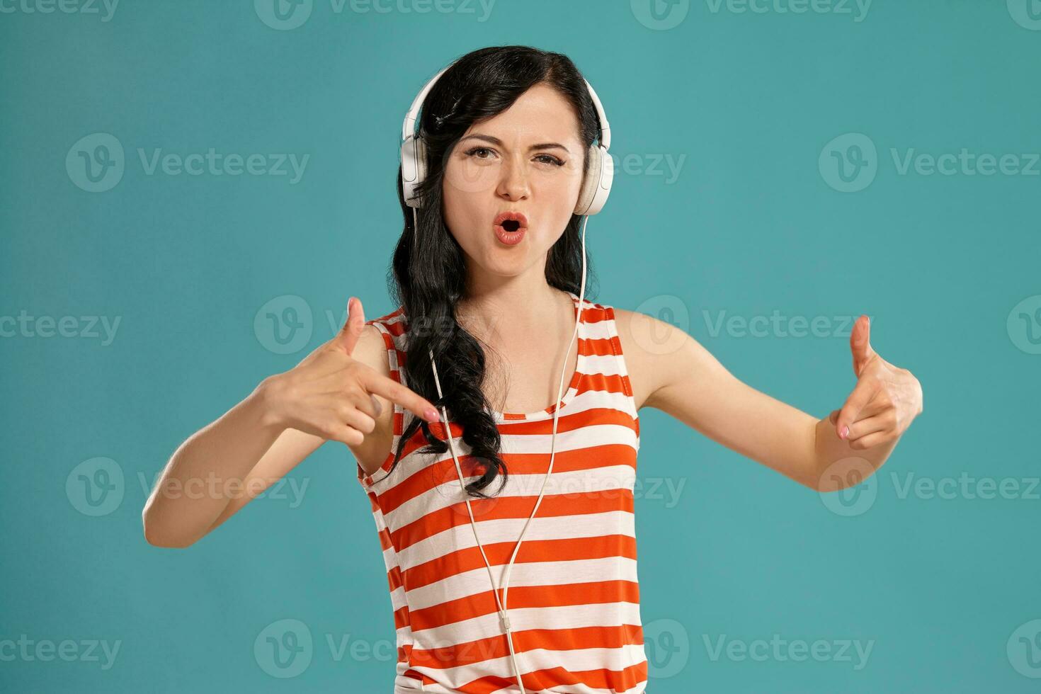 estudio foto de un maravilloso niña adolescente posando terminado un azul antecedentes.