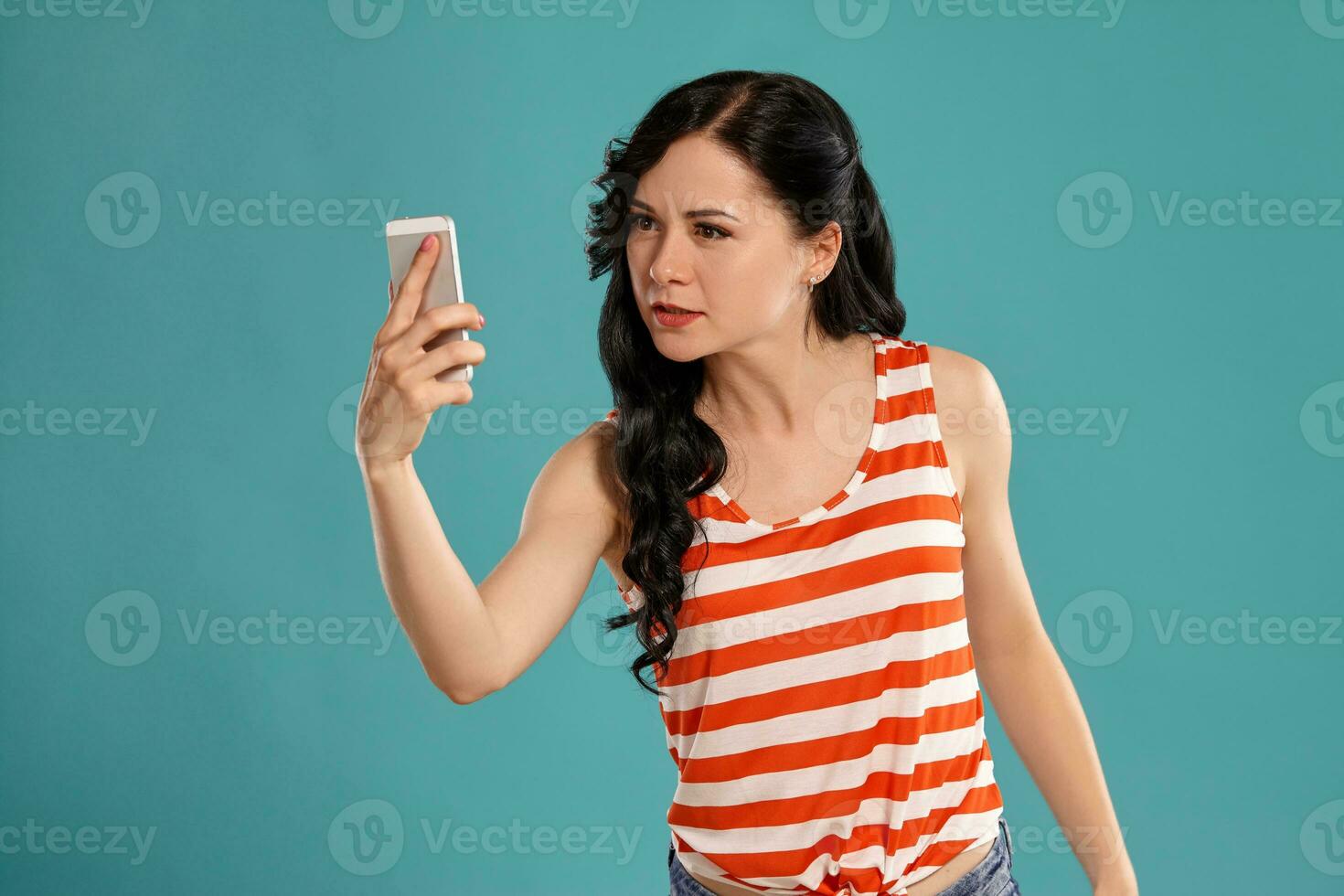 Studio photo of a gorgeous girl teenager posing over a blue background.