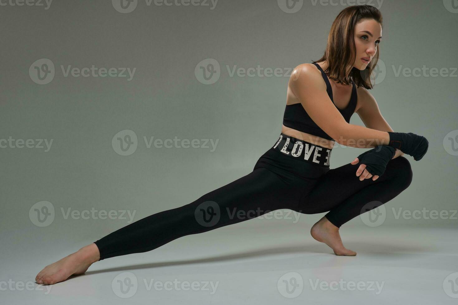 Athletic woman in boxing mittens is practicing karate in studio. photo