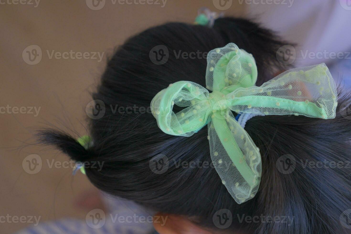 Beautiful ribbon is tied on a child hair photo