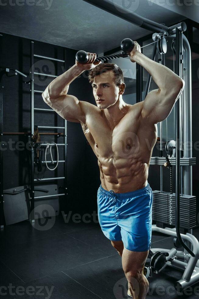 Sexy muscular man posing in gym, shaped abdominal. Strong male naked torso abs, working out photo