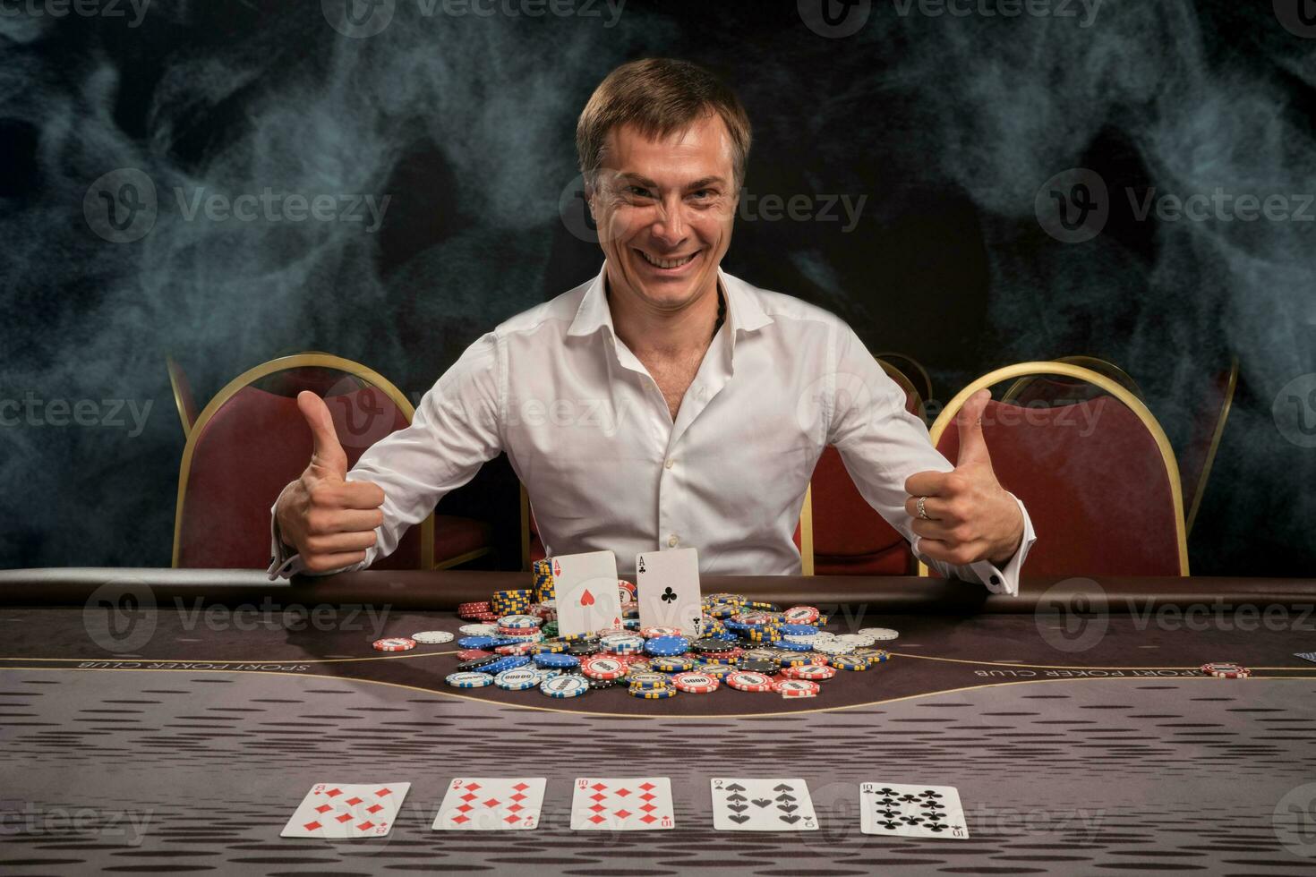 hermoso emocional hombre es jugando póker sentado a el mesa en casino. foto