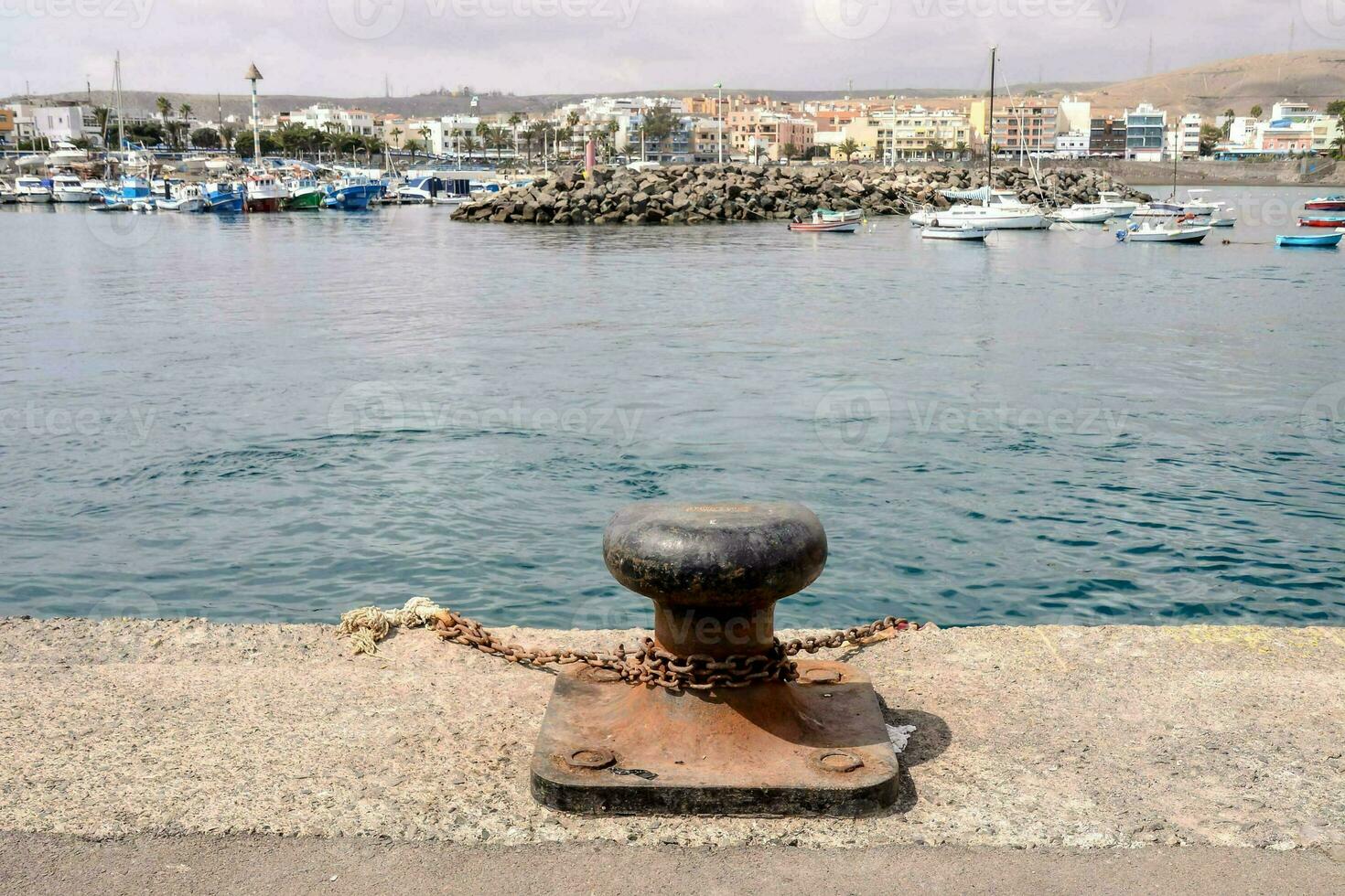 a boat anchor with a chain on the edge of a pier photo