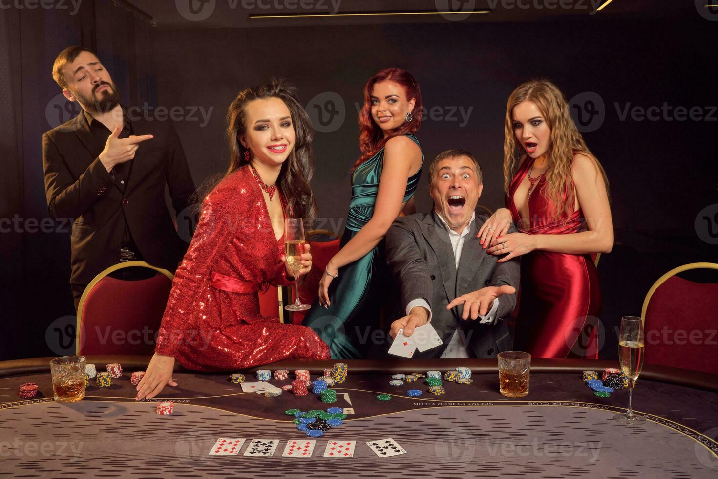Group of a young wealthy friends are playing poker at a casino. photo