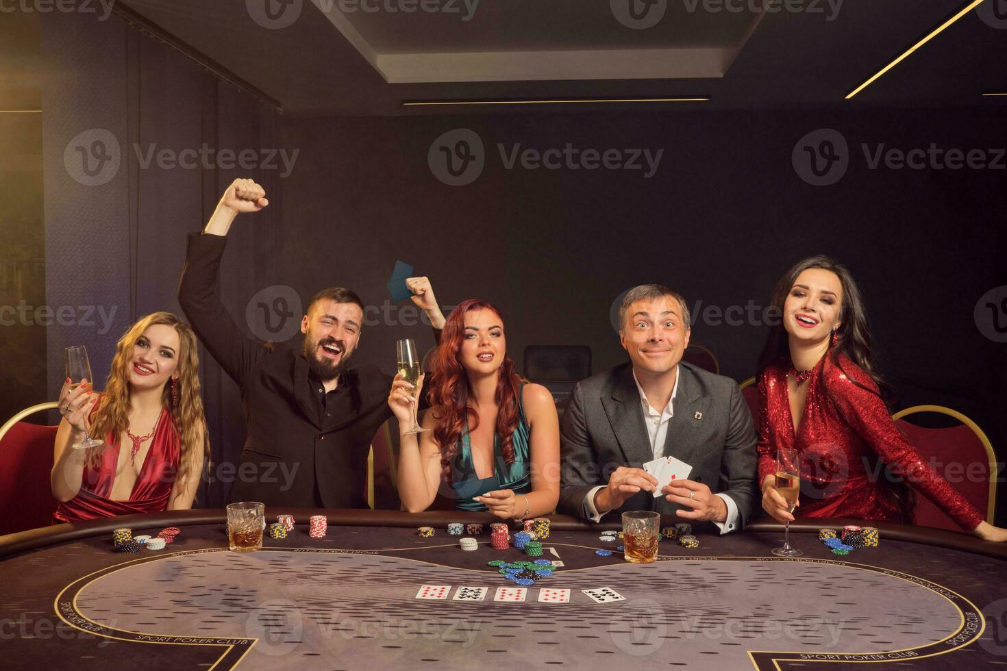Group of a young wealthy friends are playing poker at a casino. photo